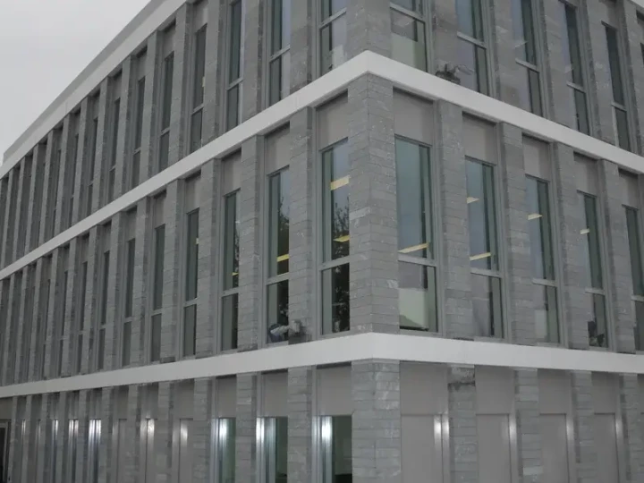 Gebäudeecke der Crédit Agricole des Savoie mit durchgehender Lamellenfassade aus San Bernardino Silber, geschliffen