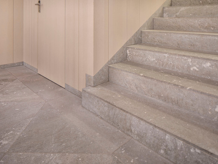 Natursteinboden und Treppe aus San Berardino Silber geschliffen mit Holzwand in der Gemeindeverwaltung Meilen Zürich.
