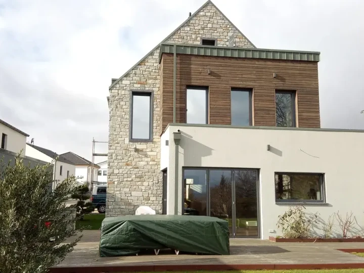 Giebelfassade eines Einfamilienhauses in Deutschland mit Natursteinmauer aus San Bernardino Silber, gespalten