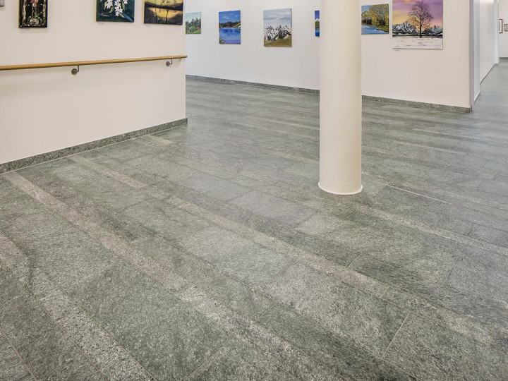 Natursteinboden Andeer Granit diamantgesägt im Flur mit Bildern und Säule im Wohnheim Solina in Spiez.