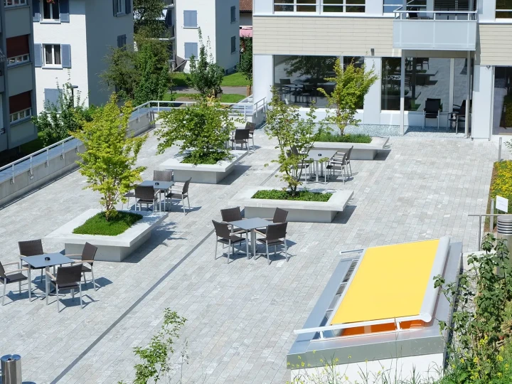 Terrasse mit San Bernardino Silber Terrassenplatten und Sitzplätzen im Spitexzentrum Ebikon.